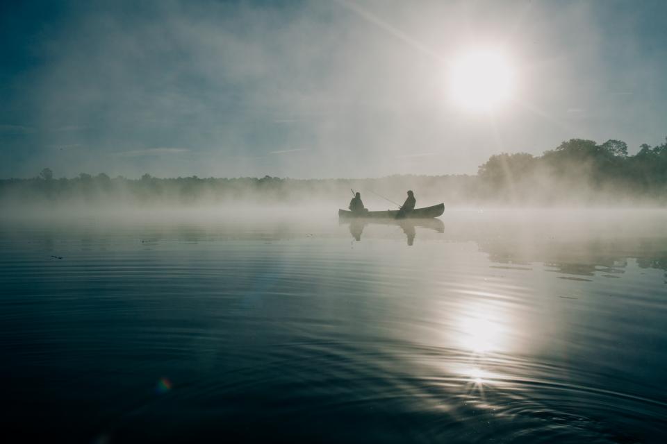 Barque sur un lac brumeux à l’aube