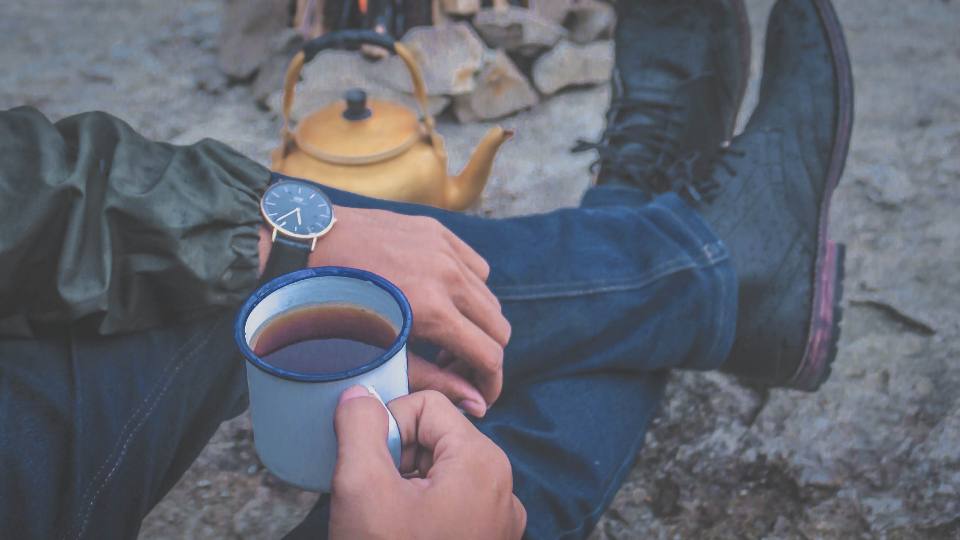 Bottes près d’un feu, tasse de café