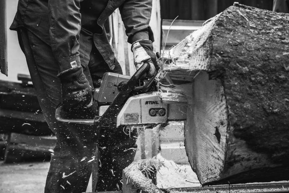 Bûcheron tranchant une grume
